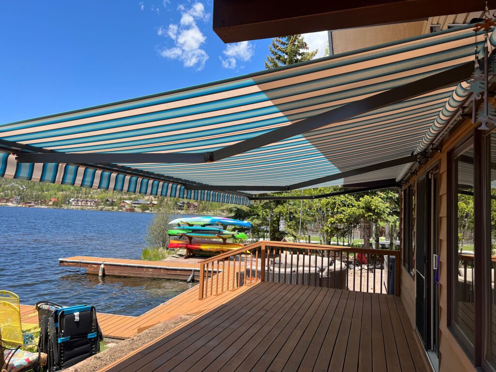 Blue striped retractable awning over lakeside deck | housetopic